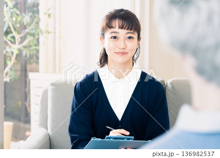 利用者と話すケアマネージャーの女性 利用者と話すケアマネージャーの女性 136982537