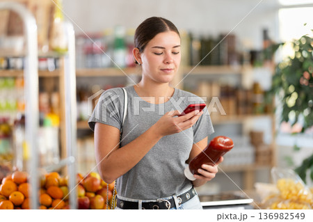 Young woman scanning qr code for ketchup 136982549
