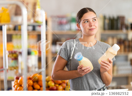 Young woman choosing mayonnaise in grocery store 136982552