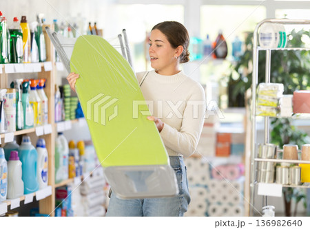 Woman choosing an ironing board Woman choosing an ironing board 136982640
