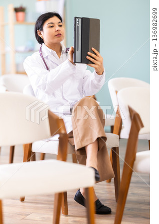 Female medical student point tablet camera at widescreen slide presentation screen 136982699