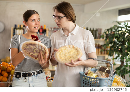 In shop European youth girl and guy scan QR code and take reading pizza using phone camera In shop European youth girl and guy scan QR code and take reading pizza using phone camera 136982746