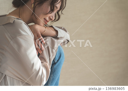 膝を抱えながら俯くおしゃれな女性(モデル,ファッションフォト,美容,ビューティ) 膝を抱えながら俯くおしゃれな女性(モデル,ファッションフォト,美容,ビューティ) 136983605