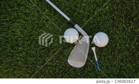 Golf grove and golf balls on a green lawn in a beautiful golf course with morning sunshine. Golf grove and golf balls on a green lawn in a beautiful golf course with morning sunshine. 136983627