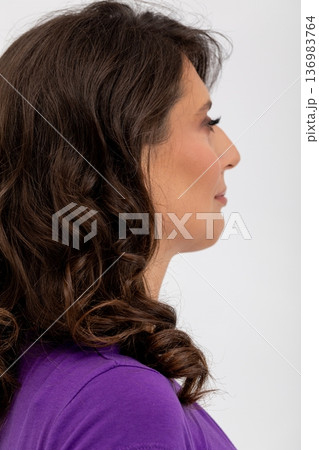 Calm artistic portrait, Quiet woman with curled hair, Serene female profile with gentle lighting, Portrait of composed woman showcasing soft makeup and elegant features 136983764