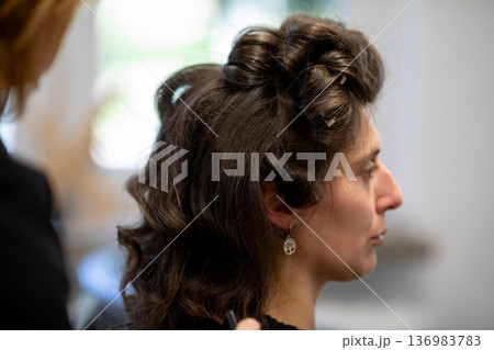 Woman in profile listening intently at concert, soft stage lighting, intricate updo, small earring visible, blurred crowd behind, grainy film texture, quiet contemplative mood Woman in profile listening intently at concert, soft stage lighting, intricate updo, small earring visible, blurred crowd behind, grainy film texture, quiet contemplative mood 136983783