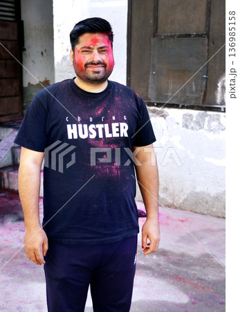 Indian Man Celebrating Holi Festival with Colored Powder Indian Man Celebrating Holi Festival with Colored Powder 136985158