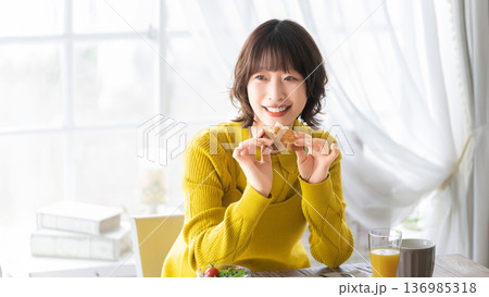 食事をする女性・朝食・パン 食事をする女性・朝食・パン 136985318