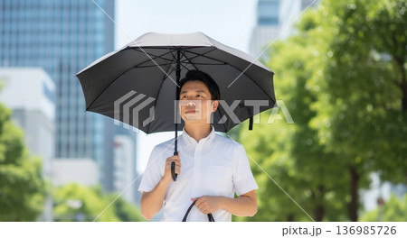 日傘をさす男性ビジネスマン 136985726