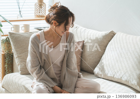 西陽の当たるリビングソファーに座る女性(モデル,ファッション,日差し) 西陽の当たるリビングソファーに座る女性(モデル,ファッション,日差し) 136986093