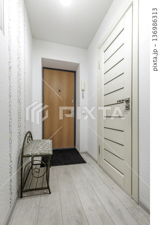 Cozy Entryway with Patterned Wallpaper and Wooden Entrance Door 136986313