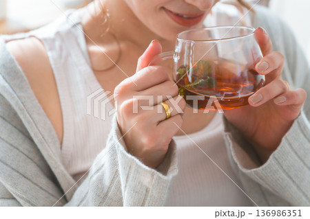 ティータイムに紅茶,ハーブティーを飲む女性の手元 ティータイムに紅茶,ハーブティーを飲む女性の手元 136986351