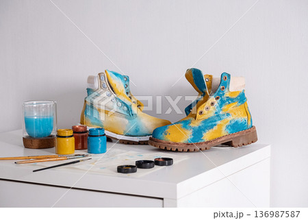 Colorful customized boots on table with paints and brushes. 136987587