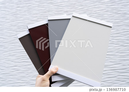 色見本で外壁塗装の色を決めるシーン　手元 136987710