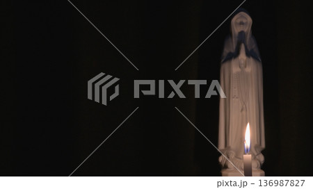 祈りと静寂のイメージ　暗闇に灯る蝋燭と聖母マリア像 136987827