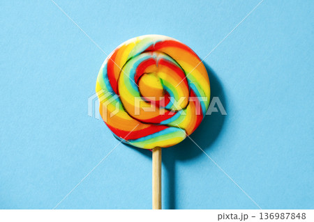 Swirl lollipop on a blue background colorful candy concept 136987848