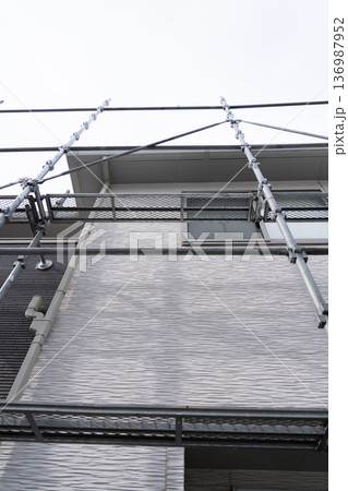 一般住宅の例　足場がけが始まった外壁修繕工事の現場 136987952