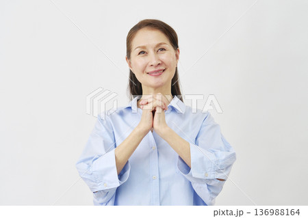 白背景で祈る高齢女性 136988164
