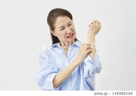 白背景で腕を掻く女性 136988184