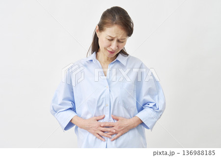 白背景で腹痛に悩む女性 白背景で腹痛に悩む女性 136988185