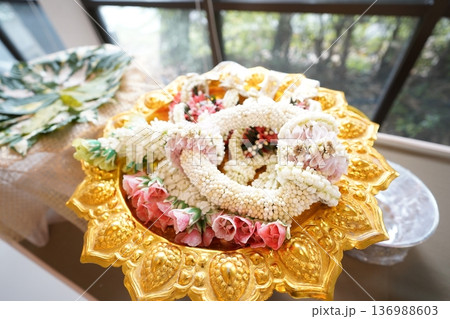 Portrait of jasmine and rose garland top golden tray. Jasmine garland is a handicraft that often used for events. Portrait of jasmine and rose garland top golden tray. Jasmine garland is a handicraft that often used for events. 136988603