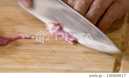 Close up of chef Butcher cutting pork meat with knife on kitchen, cooking food. The chef butcher preparing pork meat for cooking. 136988617