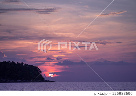 Sunset view with the cloud cover the sun on Kata Beach on Phuket island, Phuket Province, Thailand. Sunset view with the cloud cover the sun on Kata Beach on Phuket island, Phuket Province, Thailand. 136988696