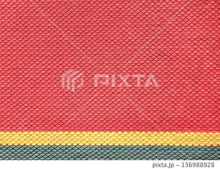Old overlapping classic asian style roofing material, Thailand. Close-up of clay roof tiles of red, yellow and green colors Old overlapping classic asian style roofing material, Thailand. Close-up of clay roof tiles of red, yellow and green colors 136988928