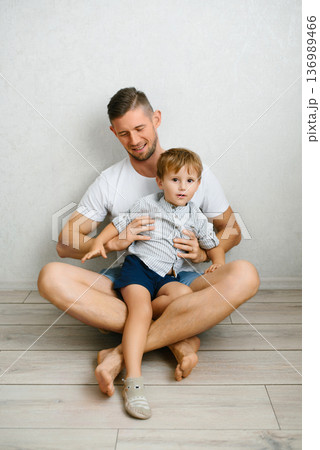 Father Holding Toddler Sitting On Floor At Home 136989466