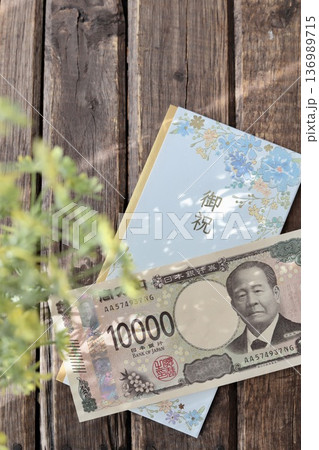 水色で花柄のご祝儀袋と新札の一万円　入学祝や進学祝などの御祝儀 136989715