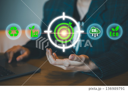 Businessperson presenting eco-friendly icons and target symbol, representing sustainable business practices and environmental goals. 136989791