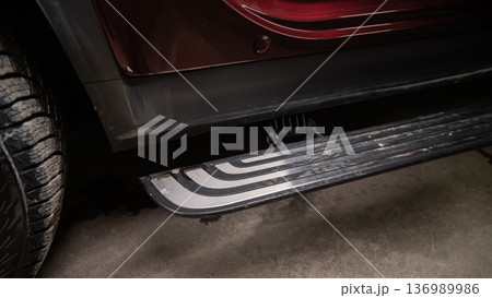 Folding step of a red modern car.  136989986