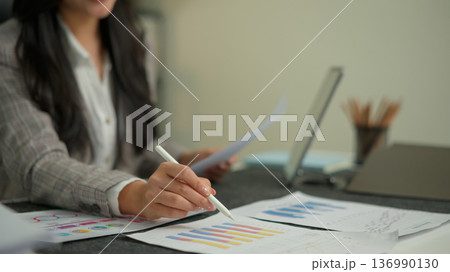 Office administrator woman reviewing audit documents data on table with digital tablet and financial file folders Office administrator woman reviewing audit documents data on table with digital tablet and financial file folders 136990130