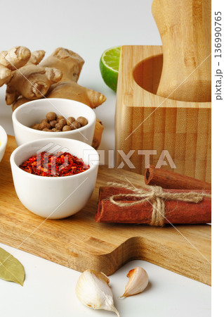 Spices and ingredients arranged on a kitchen countertop with a mortar Spices and ingredients arranged on a kitchen countertop with a mortar 136990765