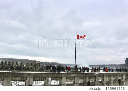冬のナイアガラの滝とカナダ国旗 観光客が集まる展望エリアの風景 136991328