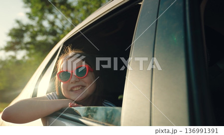 Happy girl waving from car, happy female face, summer trip sea, vacation picnic party, vacation fun, people sunglasses, travel lifestyle concept, happy travel childhood, adventure seeking kid, young 136991391