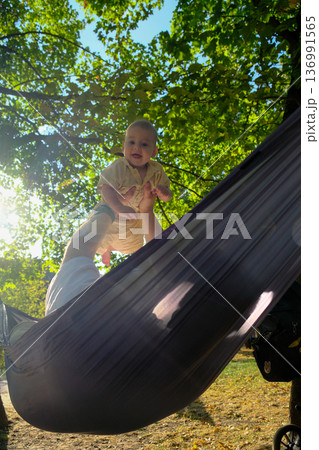Parent and Baby Enjoying Hammock Time Outdoors 136991565