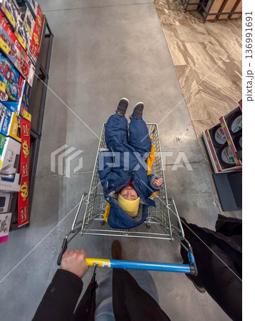 Toddler in shopping cart wearing winter snowsuit 136991691