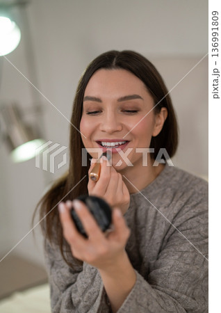 Beautiful you woman doing make up and looking contented 136991809