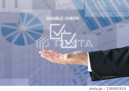 ダブルチェックのアイコンを掲げるビジネスマンの手 136991918