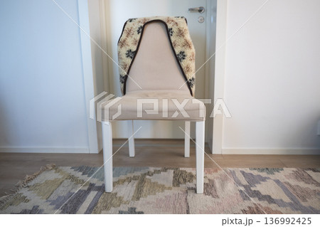 Minimalist upholstered chair with cozy blanket in Scandinavian home interior Minimalist upholstered chair with cozy blanket in Scandinavian home interior 136992425