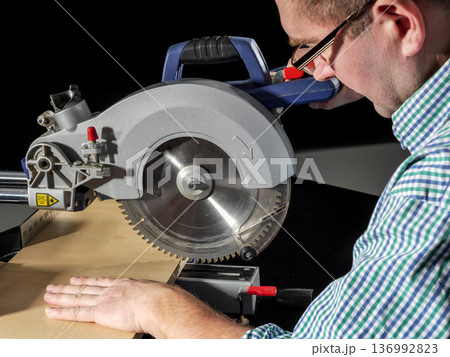Cutting plank with mitre saw Cutting plank with mitre saw 136992823