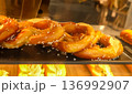 Freshly baked pretzels with salt crystals displayed in a glass case at a street bakery in paris, france 136992907