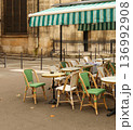 Empty traditional parisian street cafe with chairs and tables under a striped awning, a symbol of european culture and travel 136992908