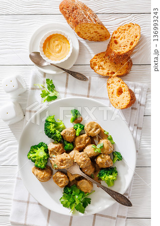 Belgian meatballs in creamy gravy with broccoli and bread 136993243