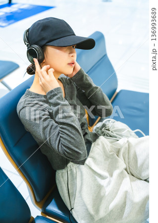 ヘッドホンで音楽を聴く女性 ■撮影協力:関西国際空港(KIX) ヘッドホンで音楽を聴く女性 ■撮影協力:関西国際空港(KIX) 136993689
