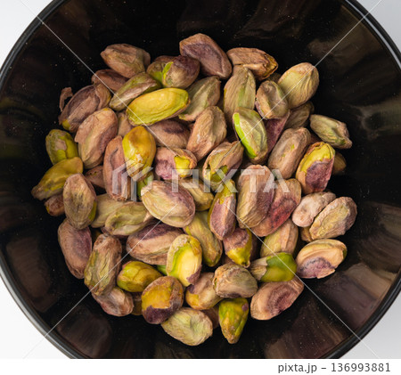 Fried salt pistachio nuts isolated. Baked pistachios pile, roasted green pistache fruits on white 136993881