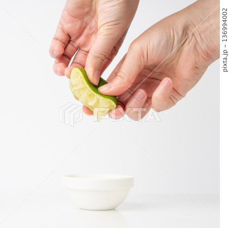 Squeezed lime isolated, squeezed out half green lemon on white background, burnout symbol 136994002