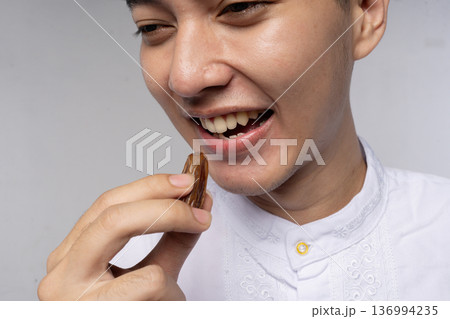 Young asian student tasting chocolate, joyful closeup 136994235