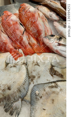 Colorful selection of fish arranged attractively on market counter 136994251